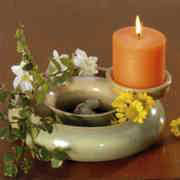 Blumenring mit orangefarbener Kerze