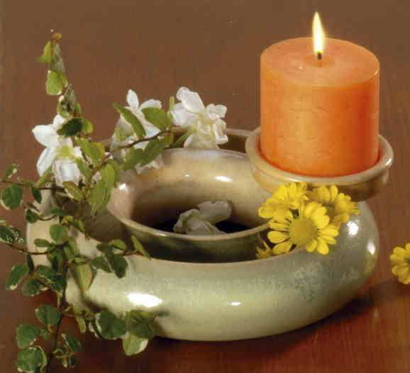Blumenring mit orangefarbener Kerze