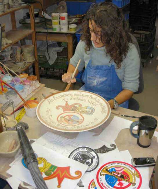 Keramikmalerin Sandra R. gestaltet einen Wandteller nach Kundenangaben zum Vereinsjubiläum